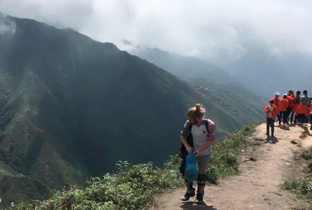 Anh T&acirc;y cần mẫn nhặt r&aacute;c ph&iacute;a sau nh&oacute;m bạn trẻ đang thả d&aacute;ng selfie tr&ecirc;n đỉnh T&agrave; X&ugrave;a - Ảnh 1.