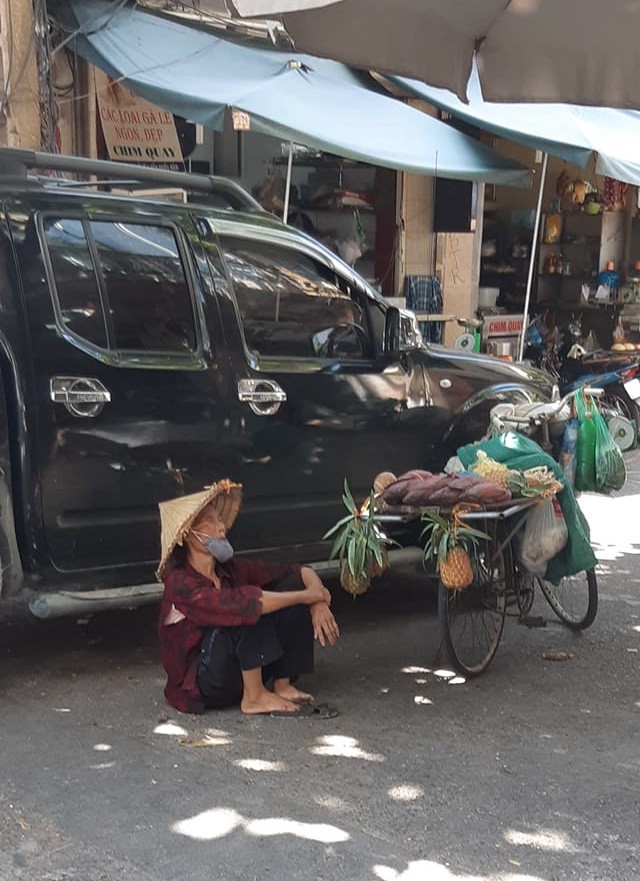 Hình ảnh bà cụ bán hàng rong ngồi nghỉ dưới bóng râm giữa cái nắng cháy da cháy thịt của Thủ đô khiến nhiều người thương cảm - Ảnh 2.