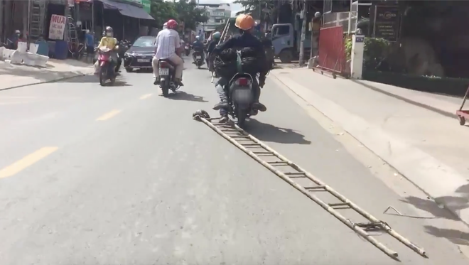 Quá lười quá nguy hiểm: Hai thanh niên đi xe máy kéo lê chiếc thang trên đường cho đỡ phải vác - Ảnh 2.