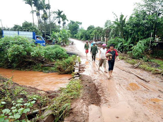 Chạy xe m&aacute;y qua v&ugrave;ng nước lũ, 2 thanh ni&ecirc;n bị cuốn tr&ocirc;i - Ảnh 1.