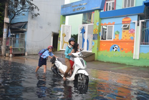 TP.HCM: Triều cường dâng cao giờ tan tầm, phụ huynh học sinh ướt sũng vượt “biển” nước về nhà - Ảnh 1.