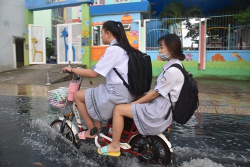 TP.HCM: Triều cường dâng cao giờ tan tầm, phụ huynh học sinh ướt sũng vượt “biển” nước về nhà - Ảnh 3.