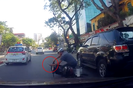 Clip: Vừa đi xe máy vừa hí hoáy bấm điện thoại, người đàn ông lao thẳng vào ô tô đậu bên đường rồi ngã lăn trước mũi xe khác - Ảnh 2.