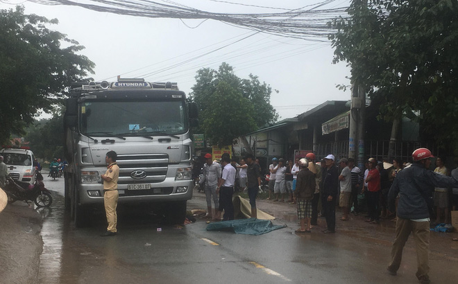 Xe ben chở cát cán chết người phụ nữ đang băng qua đường trong cơn mưa - Ảnh 1.