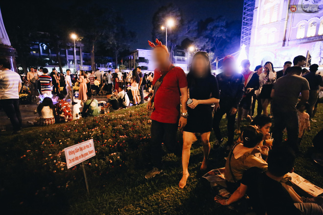 Bất chấp biển cấm, người dân vẫn giẫm đạp lên vườn hoa trước Nhà thờ Đức Bà trong đêm Noel ở Sài Gòn - Ảnh 2.