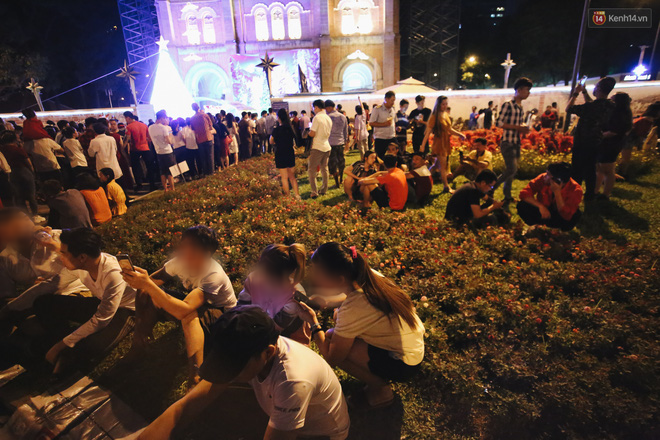 Bất chấp biển cấm, người dân vẫn giẫm đạp lên vườn hoa trước Nhà thờ Đức Bà trong đêm Noel ở Sài Gòn - Ảnh 4.