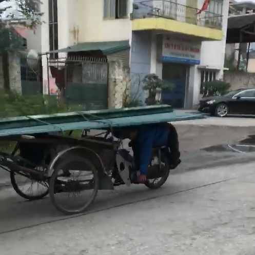 Clip: Người đàn ông nằm úp bụng lên yên, dùng lưng lái xe chở tôn chạy vi vu ngoài đường - Ảnh 2.