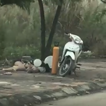 Clip: Đôi nam nữ vô tư dựng xe máy, nằm vạ vật hút bóng cười trên vỉa hè - Ảnh 2. Clip: Đôi nam nữ vô tư dựng xe máy, nằm vạ vật hút bóng cười trên vỉa hè - Ảnh 2.