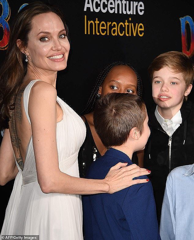 Angelina Jolie mặc áo 2 dây trẻ trung, khoe loạt hình xăm ở lưng - Ảnh 8.