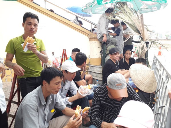 Người hâm mộ ăn bánh mỳ chống đói, chờ hàng giờ để mua vé trận U23 Việt Nam gặp U23 Myanmar - Ảnh 1.