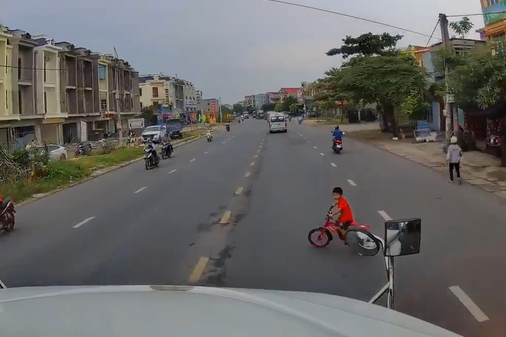 Clip: Đạp xe tạt đầu container, b&eacute; trai may mắn tho&aacute;t chết nhờ c&uacute; phanh ch&aacute;y đường của t&agrave;i xế - Ảnh 2.