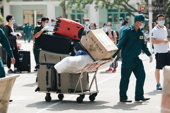 Chiếc khẩu trang ướt đẫm mồ hôi của anh dân quân ở khu cách ly, khuân vác hành lý giúp người cách ly về nhà trong niềm vui - Ảnh 2.