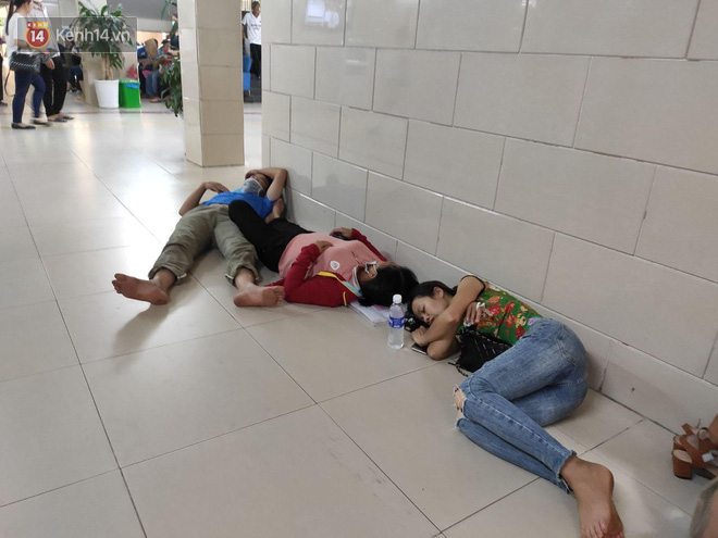 Ảnh: Nắng nóng gần 40 độ C ở Hà Nội, người nhà bệnh nhân vạ vật gần hành lang, dưới bóng cây trong bệnh viện - Ảnh 2.