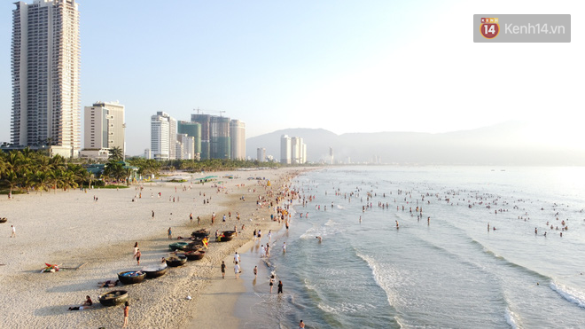 Hàng nghìn du khách và người dân ở Đà Nẵng đổ xô đi tắm biển giải nhiệt lúc sáng sớm - Ảnh 4.
