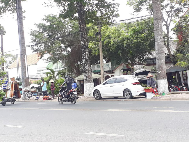 B&agrave; chủ h&agrave;ng tr&aacute;i c&acirc;y dạo cực gắt, l&aacute;i &ocirc; t&ocirc; nhưng b&igrave;nh thản mở cốp xe b&agrave;y h&agrave;ng tr&ecirc;n vỉa h&egrave; ngồi b&aacute;n - Ảnh 1.