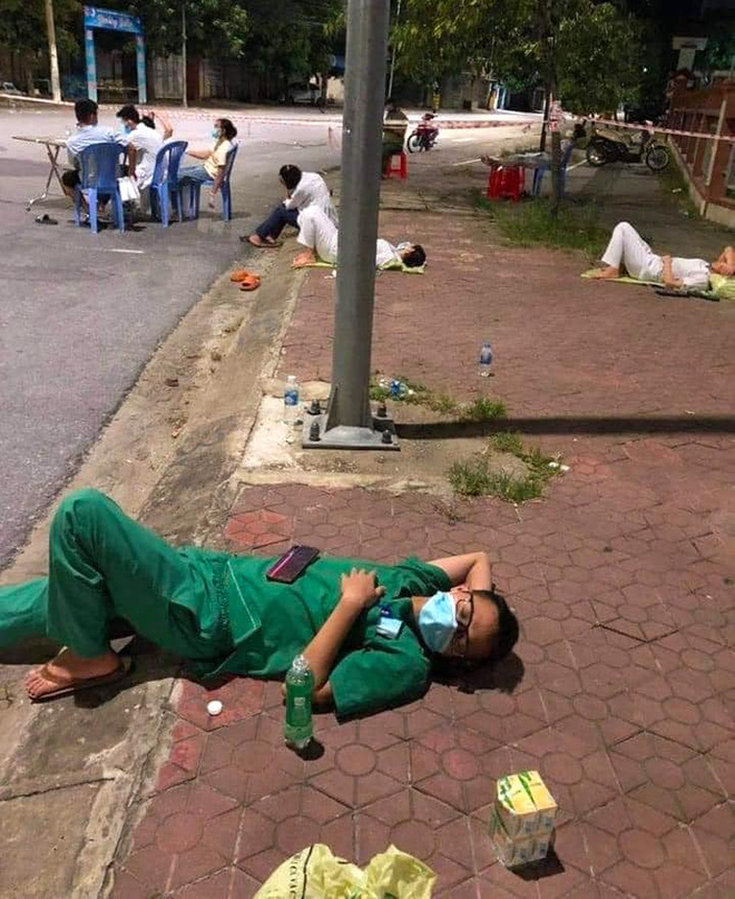 X&uacute;c động h&igrave;nh ảnh những nh&acirc;n vi&ecirc;n y tế mệt lả sau khi lấy mẫu, ngủ tạm ở vỉa h&egrave; l&uacute;c 3 giờ s&aacute;ng - Ảnh 1.