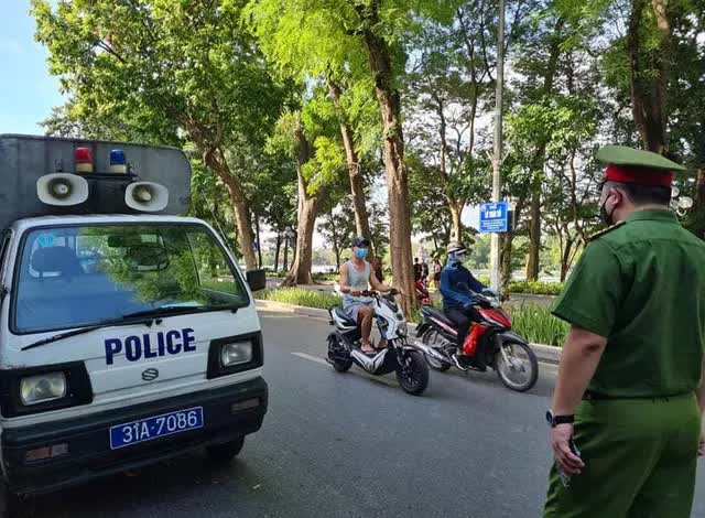 H&agrave; Nội: C&ocirc;ng an đ&oacute;n l&otilde;ng xử phạt người đi đường kh&ocirc;ng đeo khẩu trang - Ảnh 1.