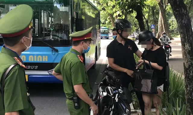 H&agrave; Nội: C&ocirc;ng an đ&oacute;n l&otilde;ng xử phạt người đi đường kh&ocirc;ng đeo khẩu trang - Ảnh 2.