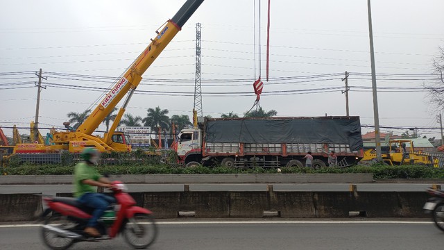 TP.HCM: Xe tải mất thắng lao dải phân cách rồi lật ngang, hàng tấn gạo đổ ra đường - Ảnh 1.