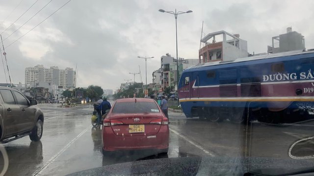 TP.HCM: Tàu hoả đi qua đường Phạm Văn Đồng nhưng gác chắn chưa hạ, nhiều người thoát nạn - Ảnh 1.