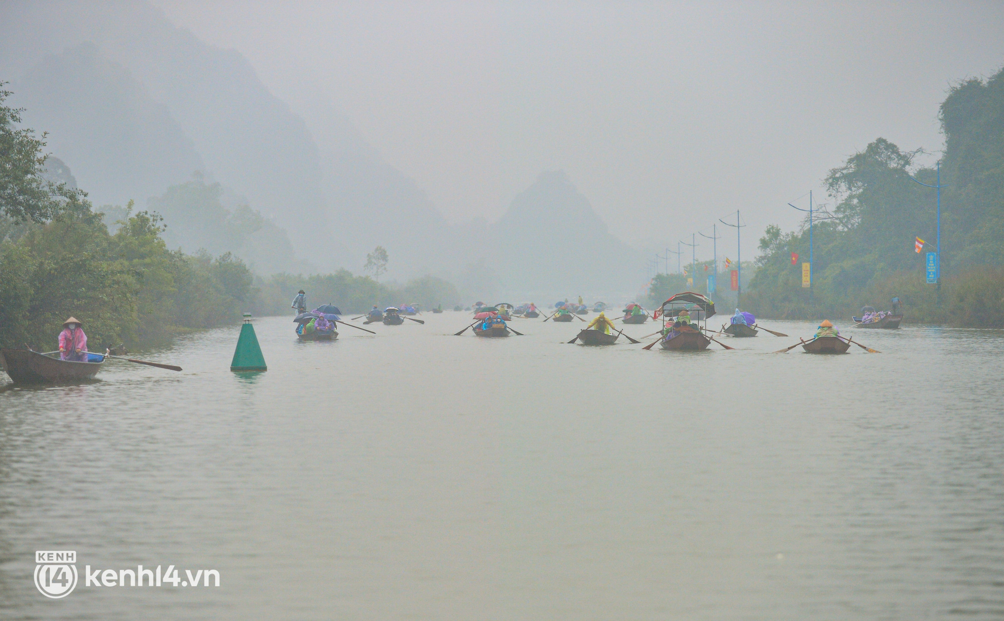 Ảnh: Người dân mặc áo mưa co rúm trên thuyền, trẻ em mệt mỏi theo cha mẹ đi lễ chùa Hương trong giá rét - Ảnh 1.