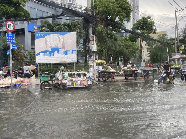 TP.HCM: Triều cường dâng cao 1,5m, người dân bì bõm trên đường ngập nước - Ảnh 9.