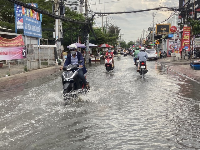 TP.HCM: Triều cường dâng cao 1,5m, người dân bì bõm trên đường ngập nước - Ảnh 6.