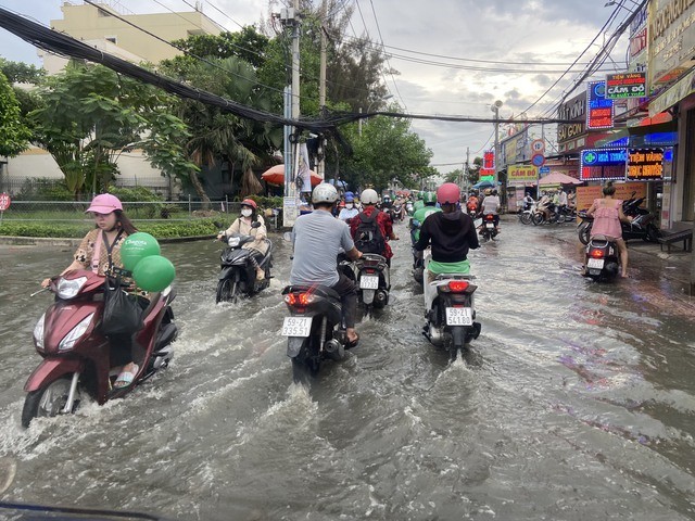 TP.HCM: Triều cường dâng cao 1,5m, người dân bì bõm trên đường ngập nước - Ảnh 3.