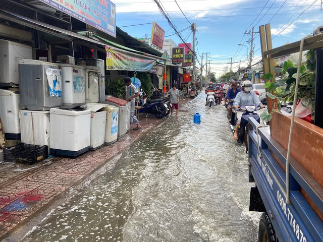 TP.HCM: Triều cường dâng cao 1,5m, người dân bì bõm trên đường ngập nước - Ảnh 2.