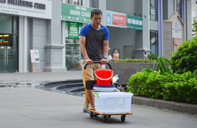 Ảnh: Người dân chung cư Hà Nội mang xô chậu đi lấy nước sạch để rửa bát, tắm gội - Ảnh 4.