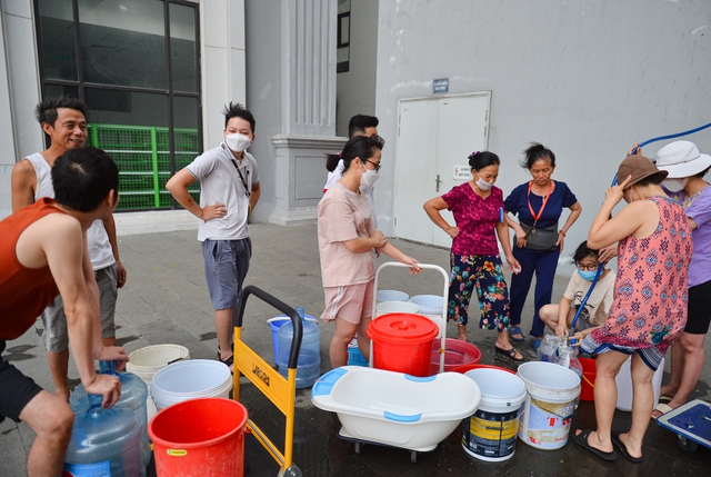 Ảnh: Người dân chung cư Hà Nội mang xô chậu đi lấy nước sạch để rửa bát, tắm gội - Ảnh 3.