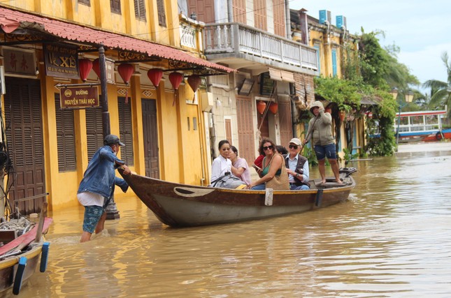 Hội An ngập sâu, du khách thuê ghe ra phố sau bão - Ảnh 1.