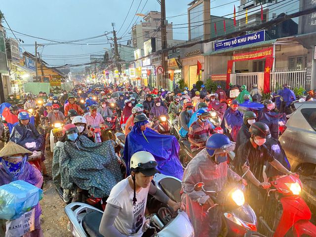 Người d&acirc;n TP.HCM vật v&atilde; trong nước ngập v&agrave; kẹt xe sau cơn mưa lớn - Ảnh 1.
