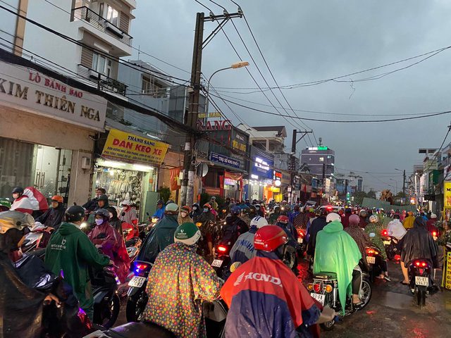 Người d&acirc;n TP.HCM vật v&atilde; trong nước ngập v&agrave; kẹt xe sau cơn mưa lớn - Ảnh 2.