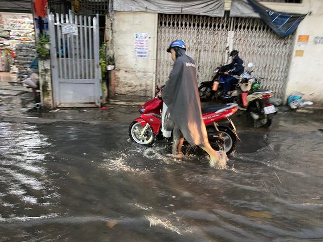 Người d&acirc;n TP.HCM vật v&atilde; trong nước ngập v&agrave; kẹt xe sau cơn mưa lớn - Ảnh 10.