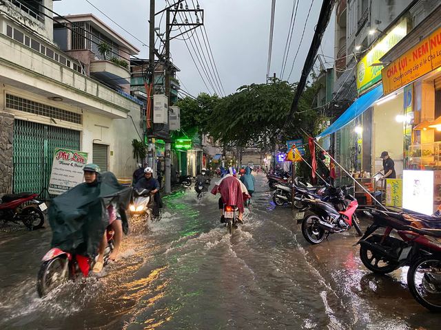 Người d&acirc;n TP.HCM vật v&atilde; trong nước ngập v&agrave; kẹt xe sau cơn mưa lớn - Ảnh 4.