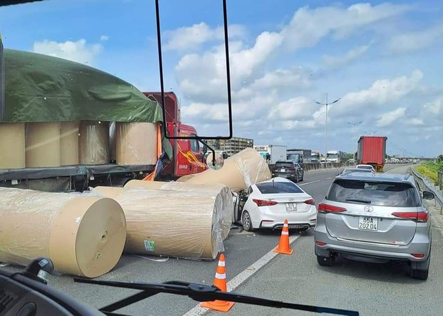 Cuộn giấy &ldquo;khổng lồ&rdquo; tr&ecirc;n xe đầu k&eacute;o rơi đ&egrave; bẹp d&uacute;m xe con, 3 người bị thương tr&ecirc;n cao tốc TP.HCM &ndash; Trung Lương - Ảnh 1.