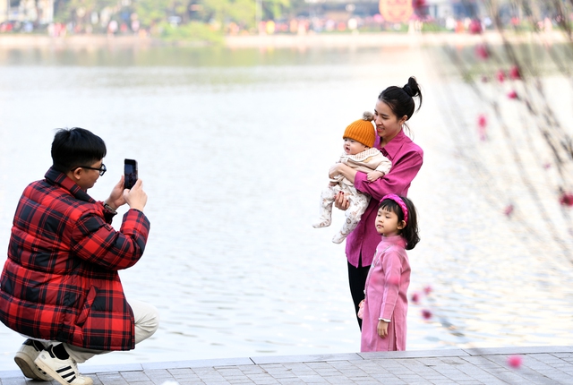 Người dân xúng xính áo dài đổ về hồ Gươm dạo chơi, chụp ảnh trong ngày cuối năm Nhâm Dần - Ảnh 1.