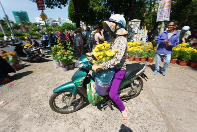 Chiều 30 Tết, hạ giá rẻ bèo vẫn không có người mua, tiểu thương bỏ thêm tiền chở hoa về - Ảnh 5.