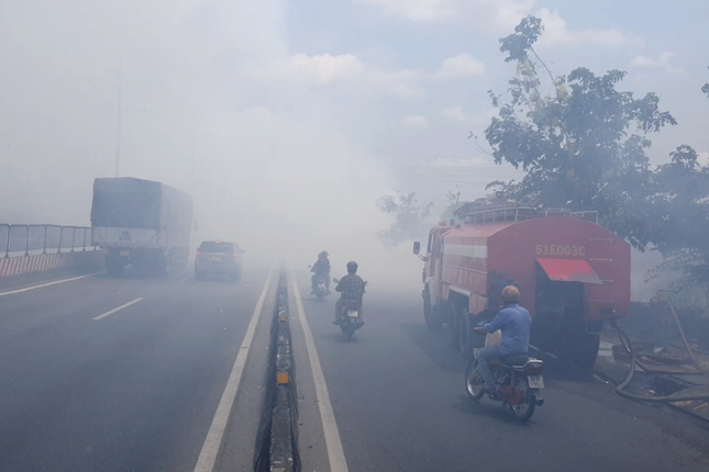 Khói trắng bao phủ quốc lộ, hàng trăm người dân bịt mũi vượt qua - Ảnh 3.