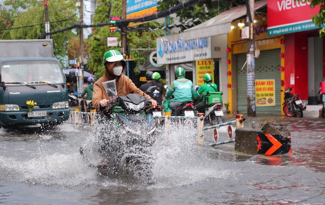 Nhiều tuyến đường ở TP.HCM biến thành sông sau mưa to: Ô tô chết máy phải nhờ xe khác kéo về - Ảnh 5.