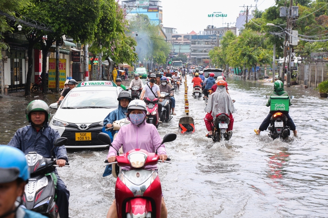 Nhiều tuyến đường ở TP.HCM biến thành sông sau mưa to: Ô tô chết máy phải nhờ xe khác kéo về - Ảnh 1.