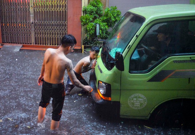 Hà Nội: Hàng loạt tuyến phố ngập nặng sau cơn mưa lớn, người dân bì bõm lội trong nước - Ảnh 10.