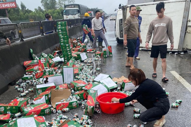 Hàng trăm thùng bia đổ ra đường vì xe tải lật - Ảnh 1.