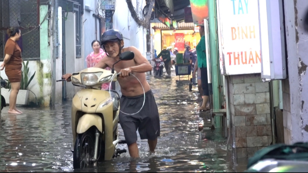 TP.HCM: Người dân vật lộn tát nước ra khỏi nhà vì triều cường kèm mưa lớn- Ảnh 2.