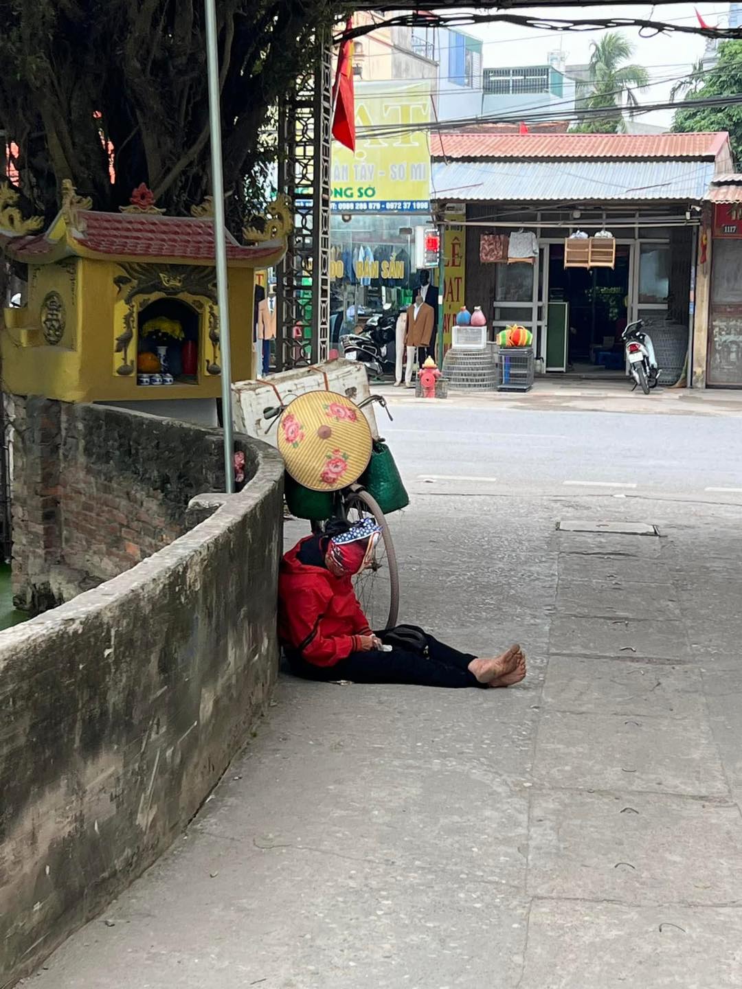 Người phụ nữ mệt mỏi ngủ gục ven đường cạnh chiếc xe đạp, thứ c&ocirc; nắm chặt tr&ecirc;n tay c&agrave;ng khiến người ta x&oacute;t xa- Ảnh 1.