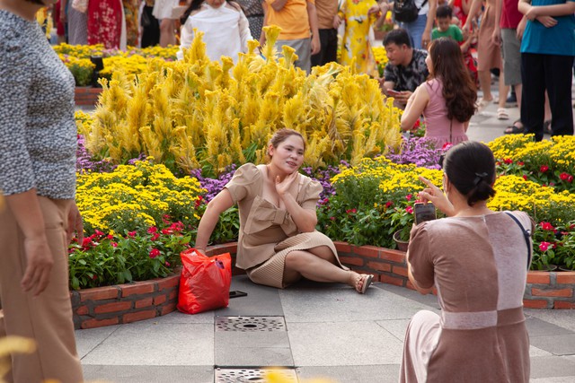 Hội chị em bạn dì diện áo dài Tết, tạo dáng đủ kiểu trên đường hoa Nguyễn Huệ - Ảnh 13.