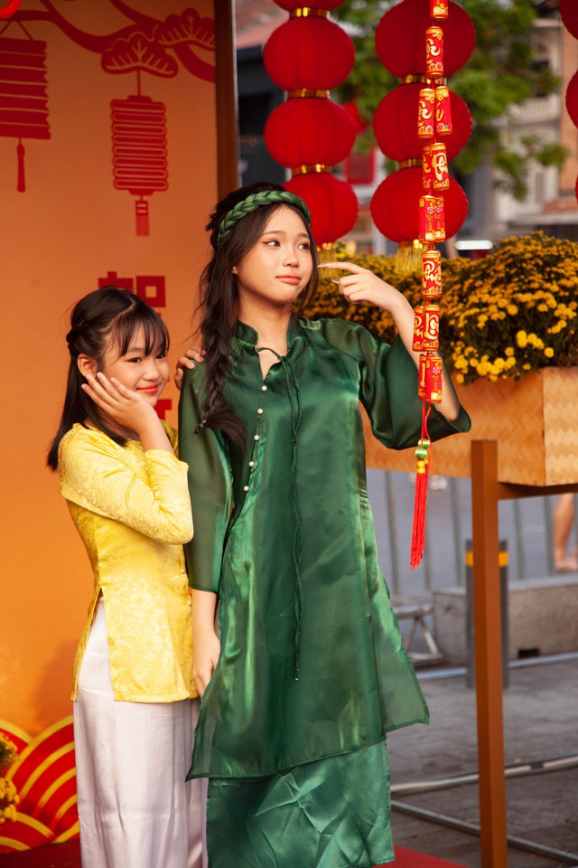 Hội chị em bạn dì diện áo dài Tết, tạo dáng đủ kiểu trên đường hoa Nguyễn Huệ - Ảnh 4.
