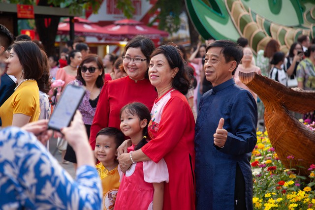 Hội chị em bạn dì diện áo dài Tết, tạo dáng đủ kiểu trên đường hoa Nguyễn Huệ - Ảnh 3.