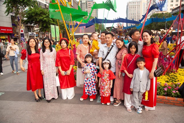 Hội chị em bạn dì diện áo dài Tết, tạo dáng đủ kiểu trên đường hoa Nguyễn Huệ - Ảnh 2.